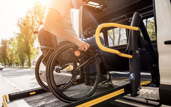 Mann mit Rollstuhl nutzt Taxi mit Rampe
