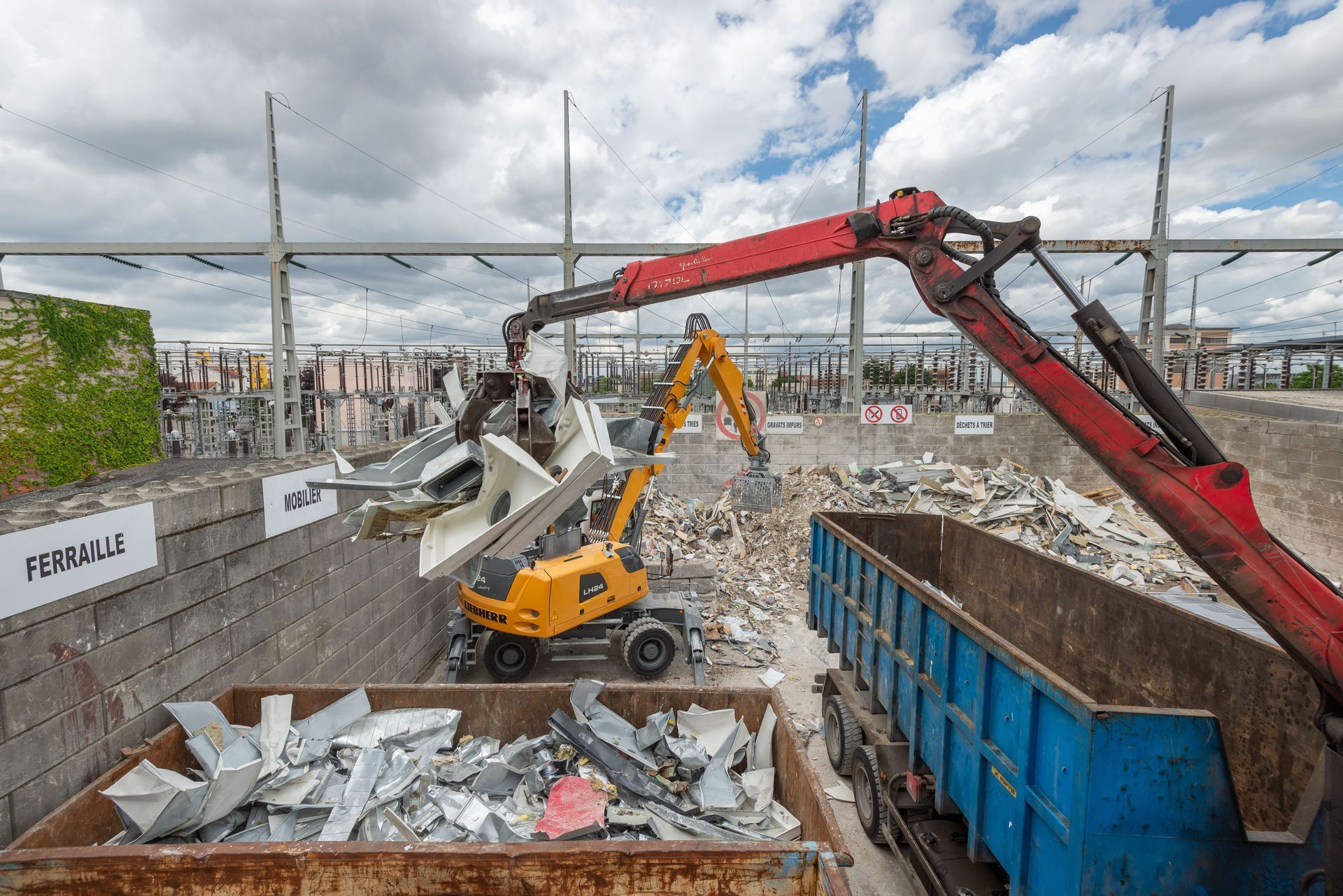 Pince mécanique prenant des matériaux dans une benne dans la déchetterie.