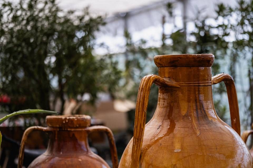 Zwei Tonvasen mit Henkeln stehen nebeneinander auf einem Tisch.