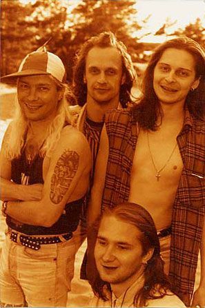 Joukko miehiä seisoo vierekkäin kädet ristissä.