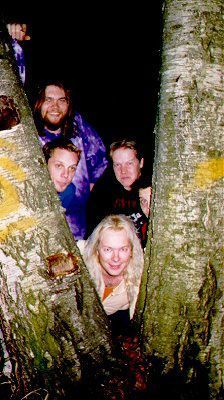 Ryhmä ihmisiä seisoo vierekkäin puussa.