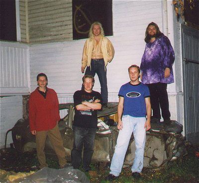 Ryhmä miehiä poseeraa kuvaa varten ja yhdellä heistä on yllään sininen paita, jossa lukee 