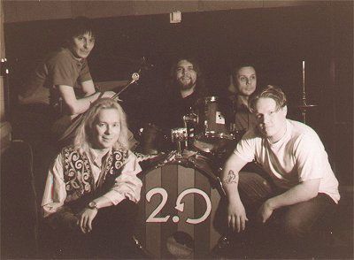 Ihmisryhmä poseeraa rummun edessä, jossa on numero 2.0