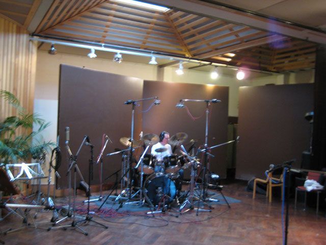 Mies soittaa rumpuja suuressa huoneessa