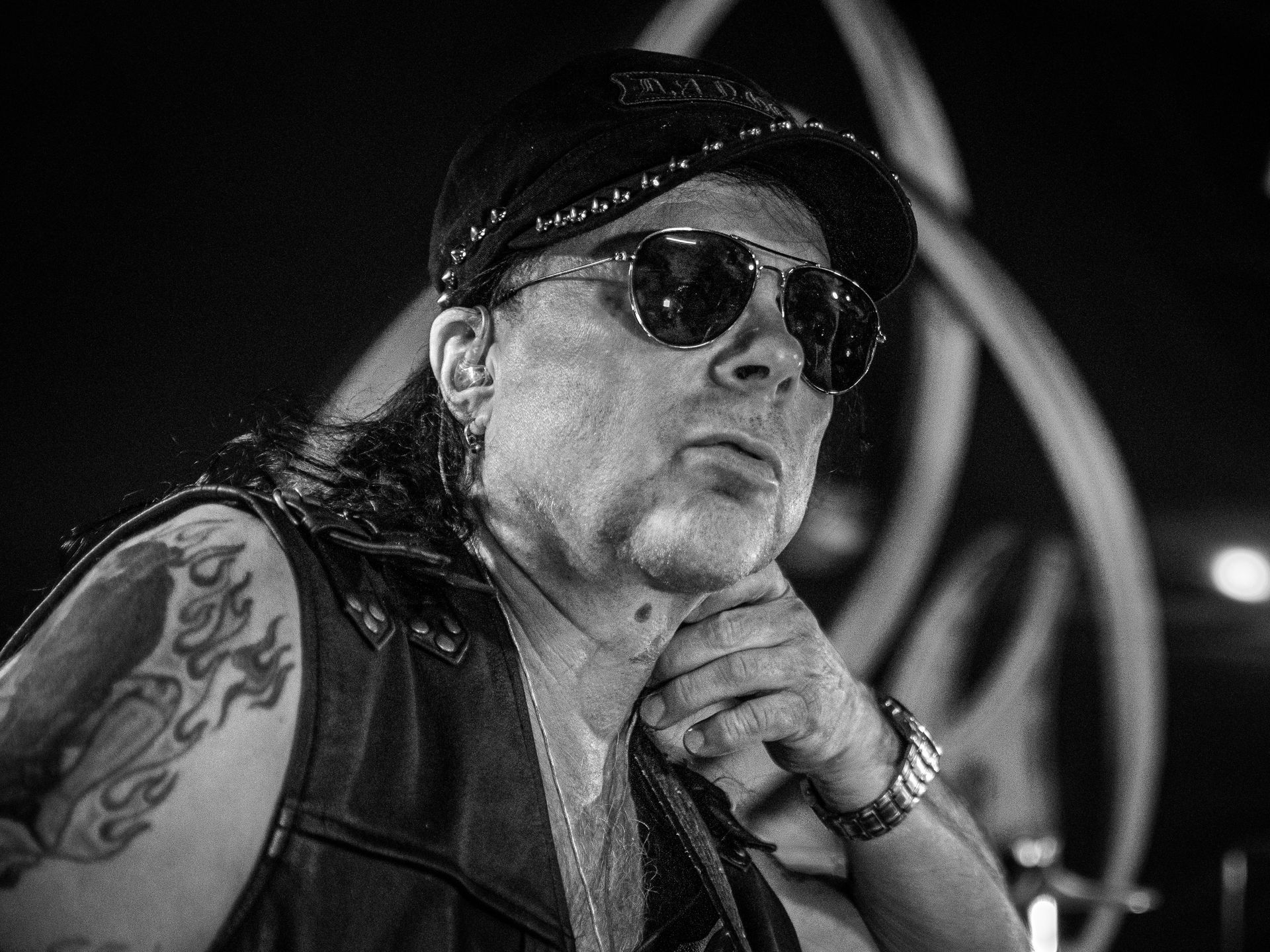 Mustavalkoinen valokuva miehestä, jolla on aurinkolasit ja hattu.