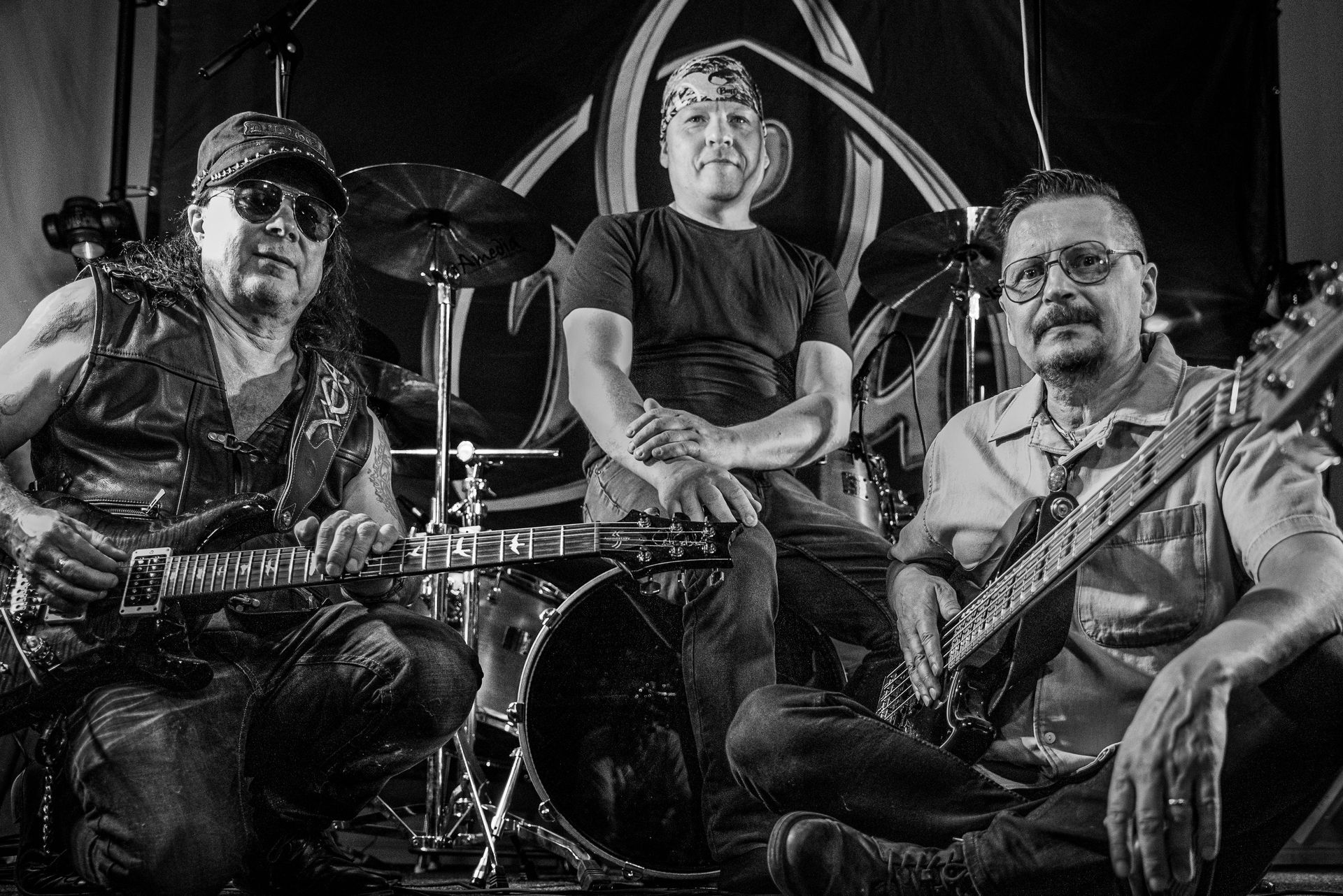 Mustavalkoinen valokuva kolmesta miehestä soittamassa instrumentteja bändissä.