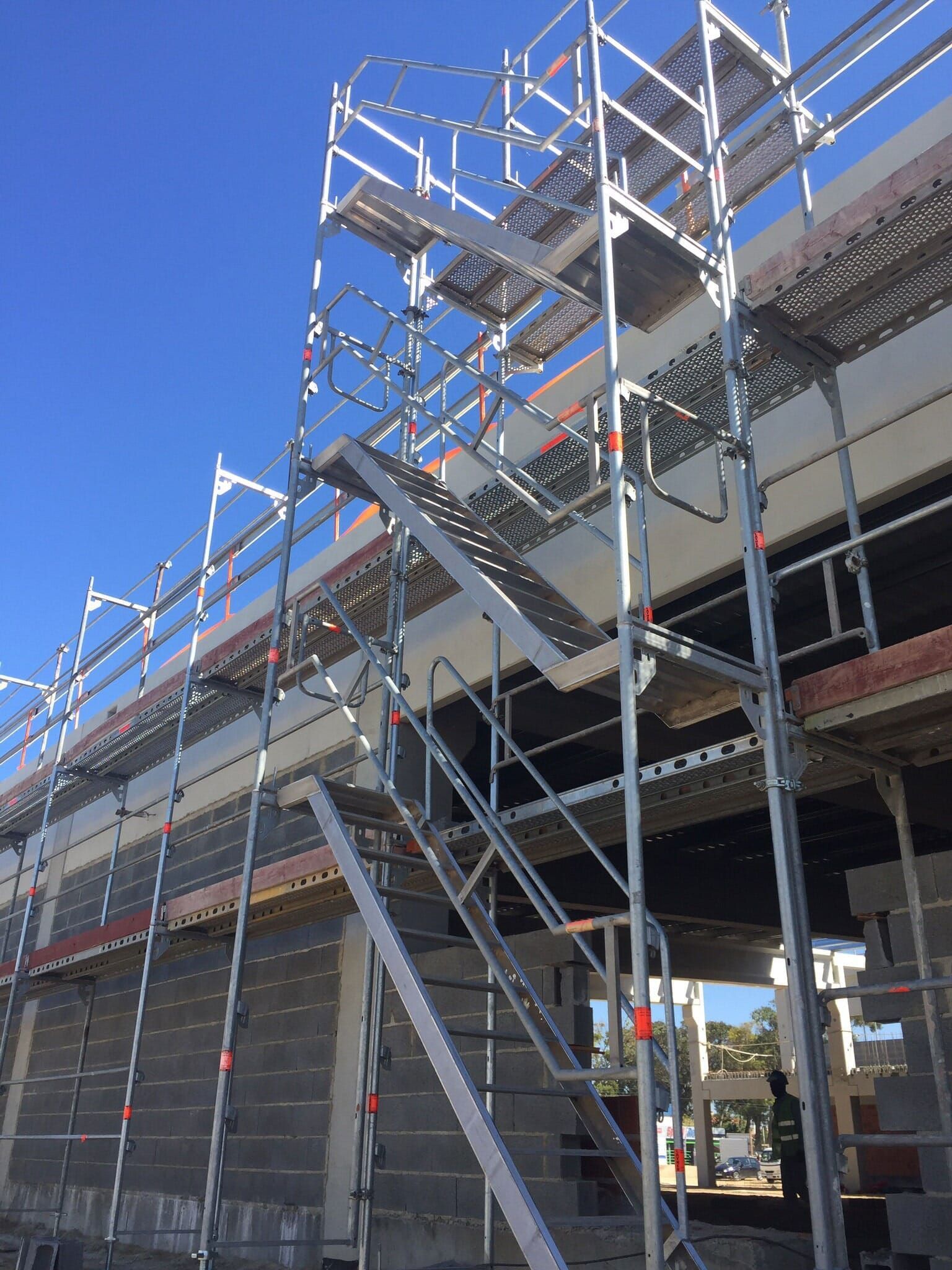 Uma ponte está sendo construída com andaimes e escadas.