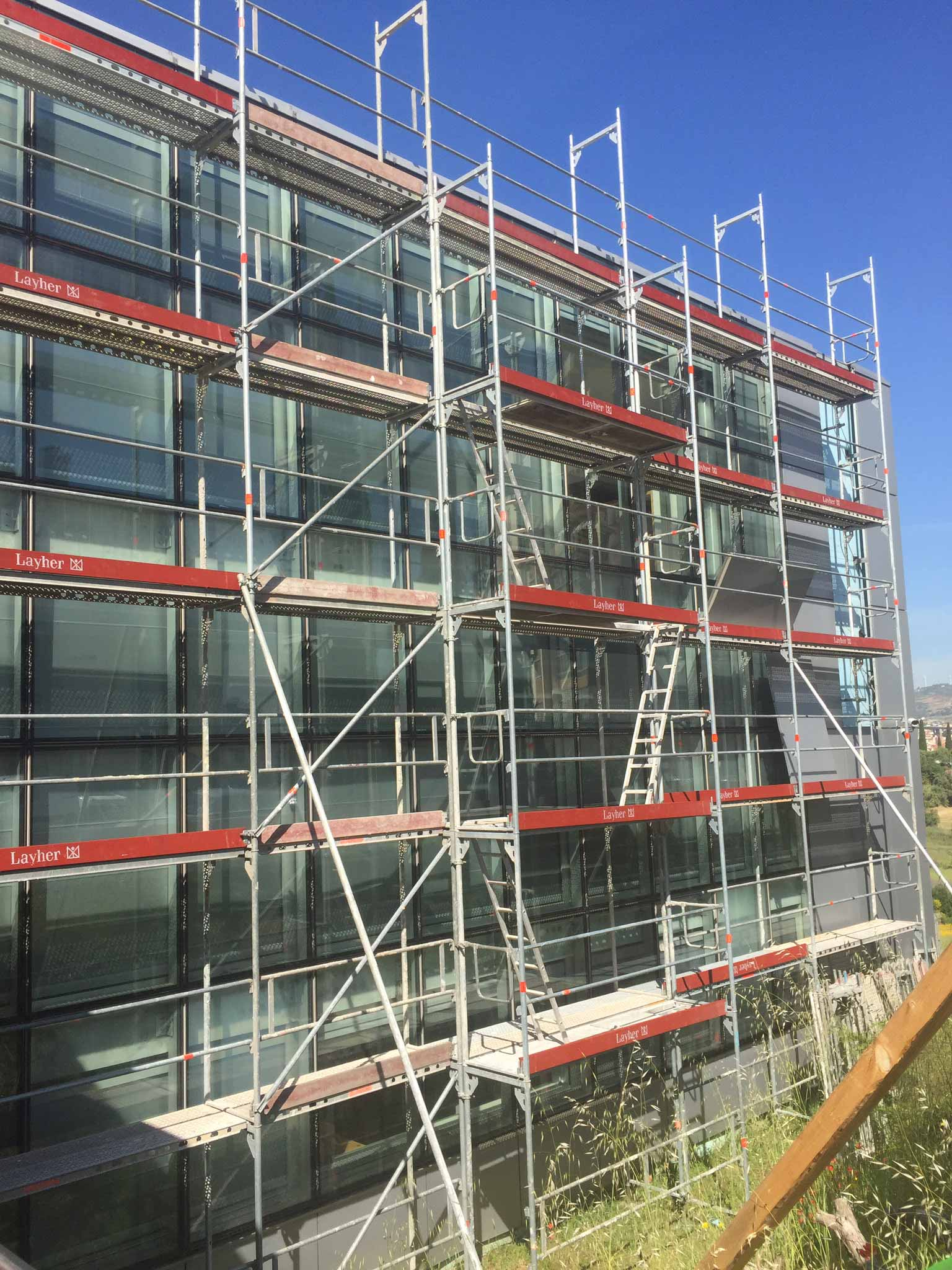 Um grande edifício está sendo construído com andaimes ao redor.