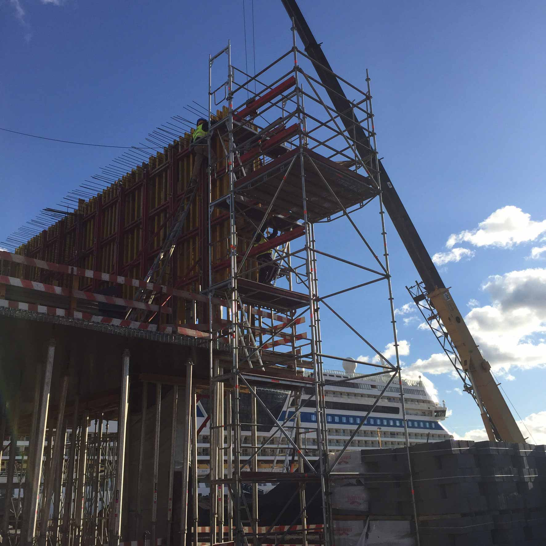 Um grande navio de cruzeiro está ao fundo de um canteiro de obras