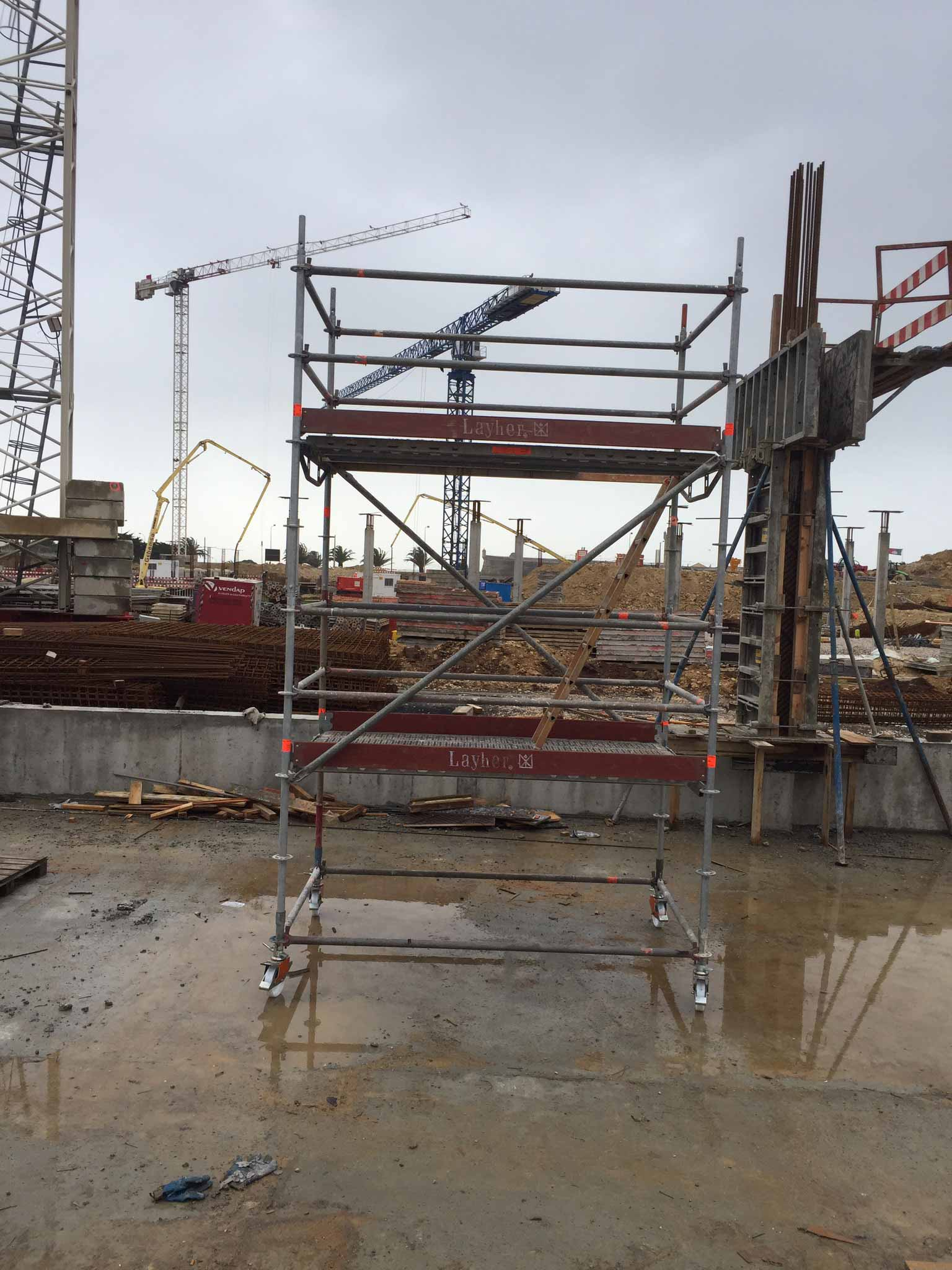 Um canteiro de obras com andaimes e um guindaste ao fundo