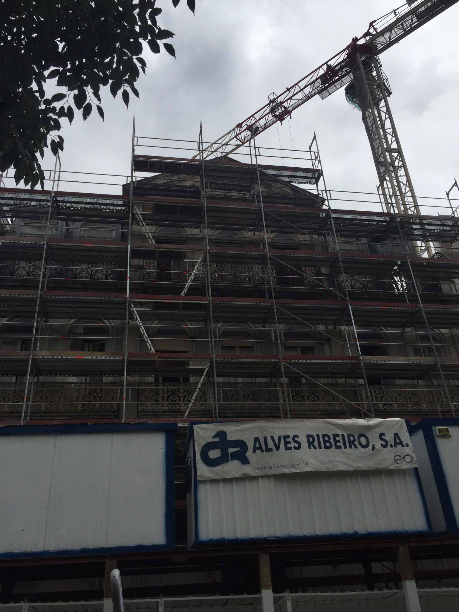 Um prédio em construção com andaimes e uma placa que diz alves ribeiro sa