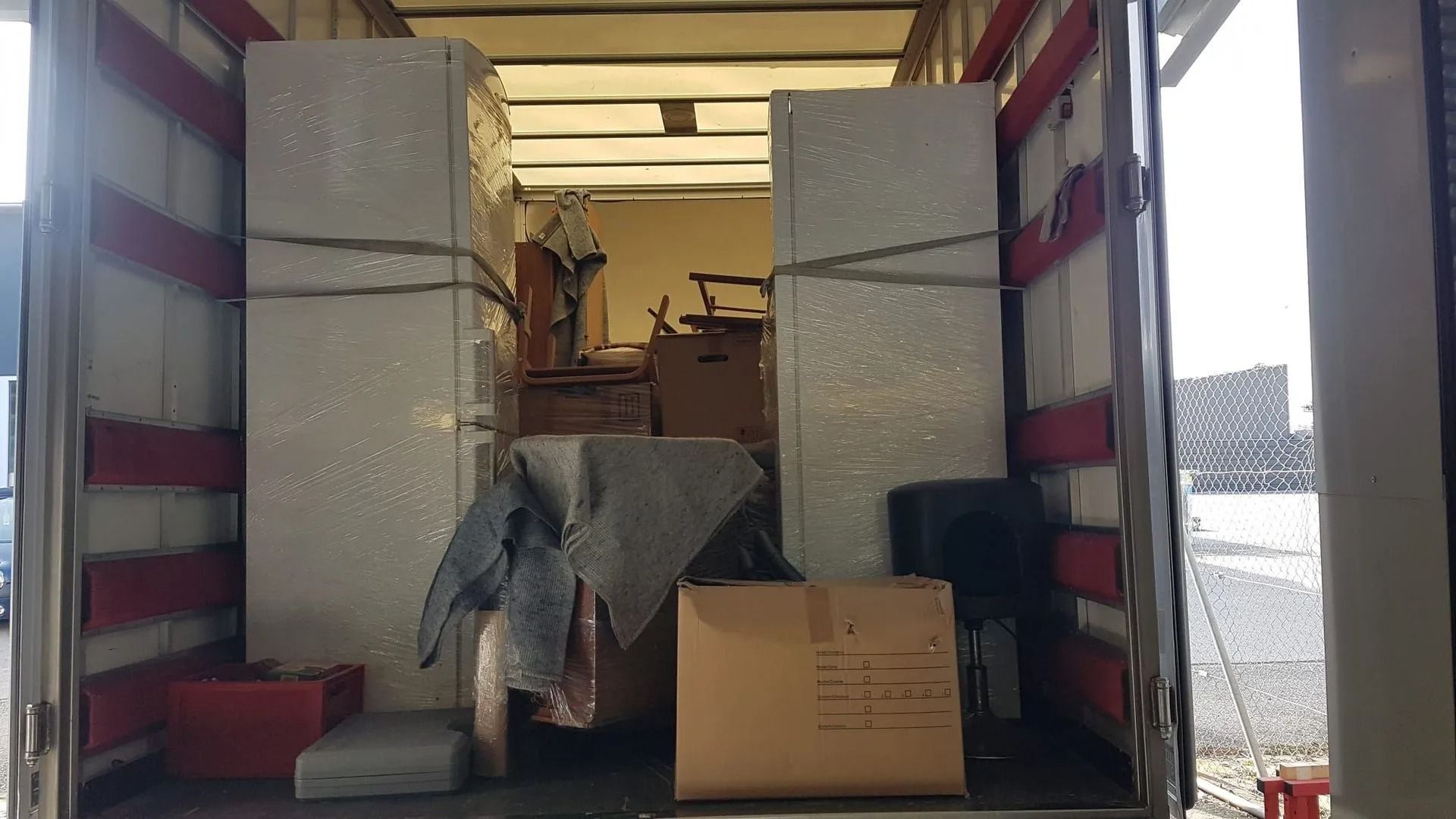 À l'intérieur d'un camion de déménagement chargé de meubles, de cartons et de divers articles ménagers.