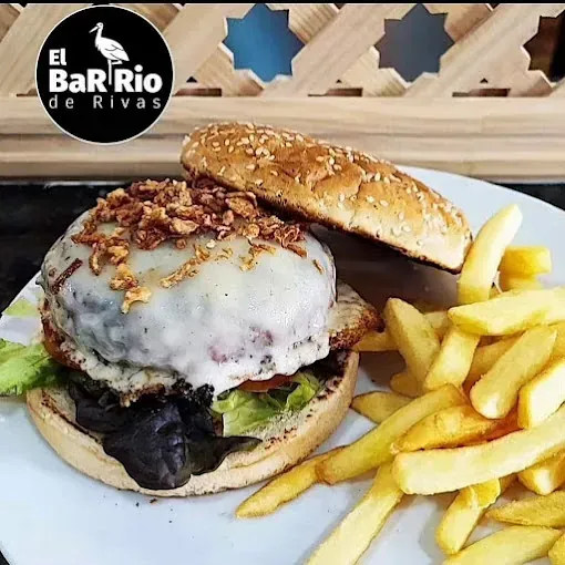 Una hamburguesa y papas fritas en un plato blanco del barrio de Rivas.