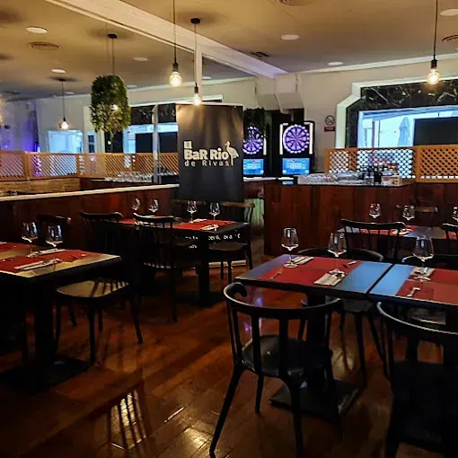 Un restaurante con mesas y sillas y un cartel que dice bar rio de kings
