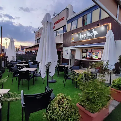 Un restaurante con mesas, sillas y sombrillas al aire libre.