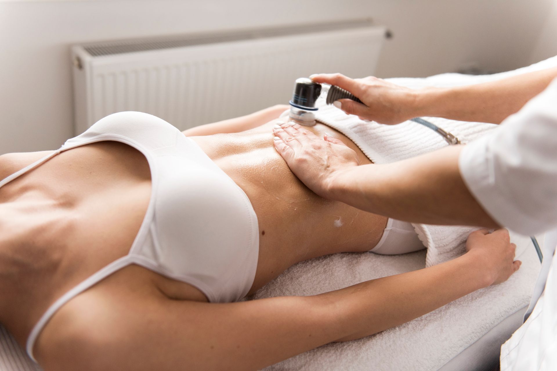 Femme recevant un soin de la peau abdominale avec un appareil portatif dans un spa