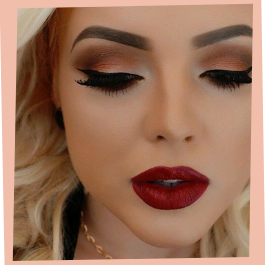 Gros plan sur un visage aux yeux fermés, sourcils marqués, trait d'eyeliner et rouge à lèvres rouge foncé