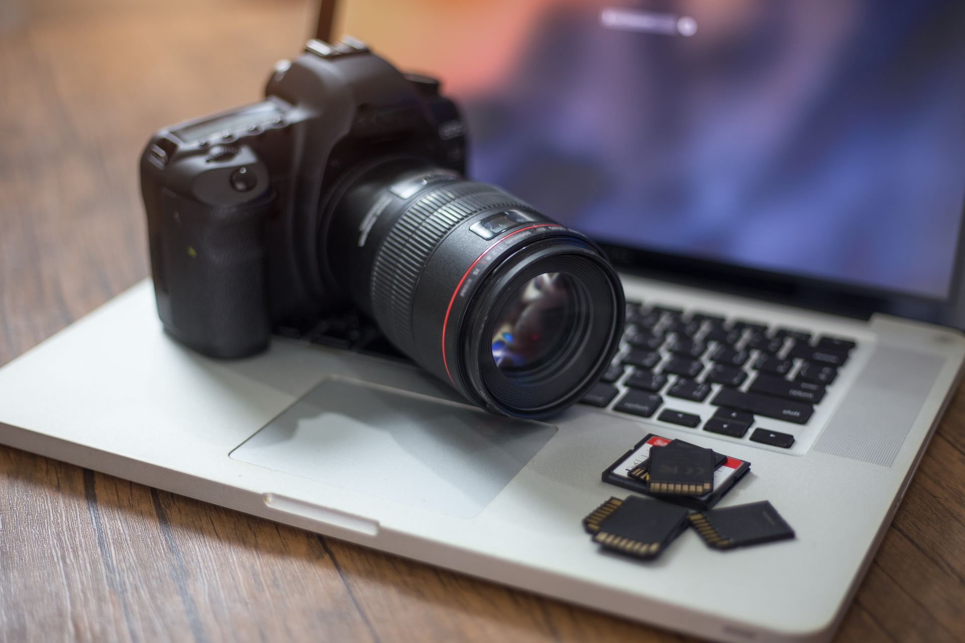 Appareil photo posé sur un ordinateur avec des cartes mémoires