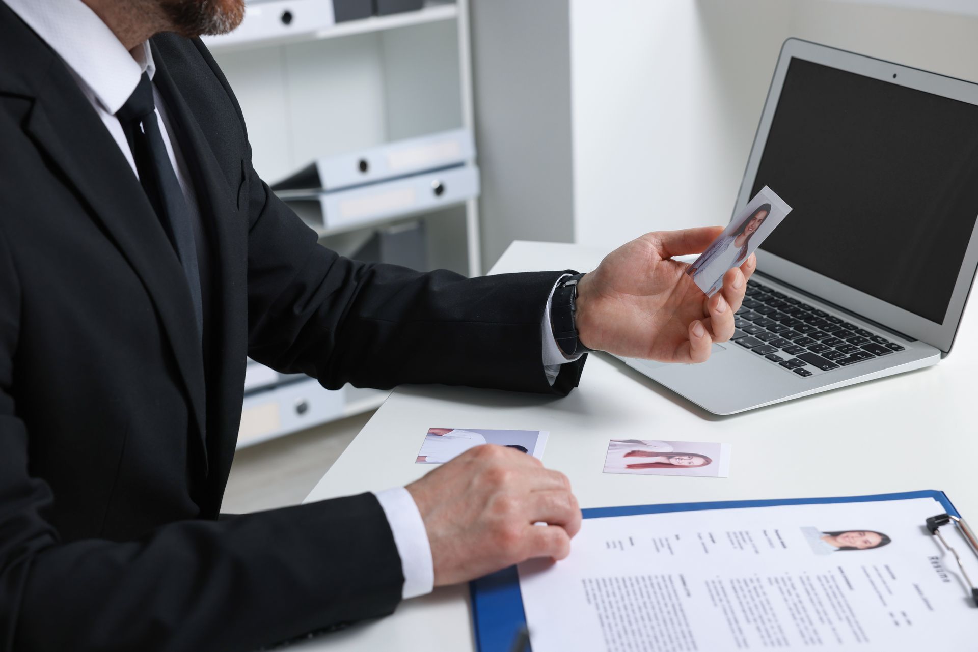 Homme en costume qui tient une photo d'identité en main