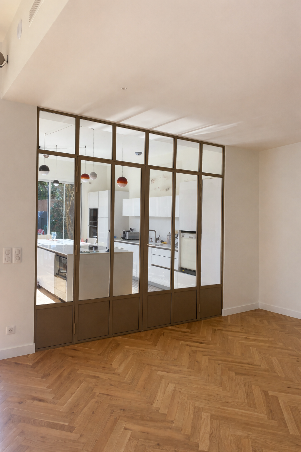 Un ouvrier portant des gants de travail installe un cadre de fenêtre dans une structure en bois, ses outils se trouvant à proximité.