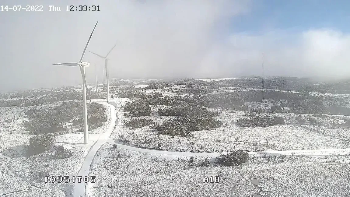 Una vista aérea de una turbina eólica en medio de un campo nevado.