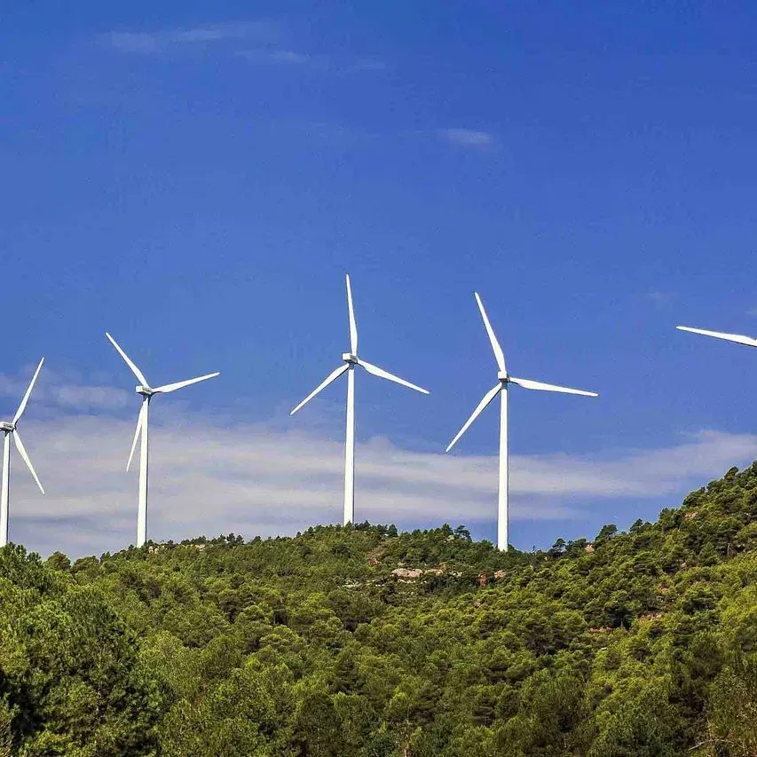 Una hilera de turbinas eólicas en la cima de una colina