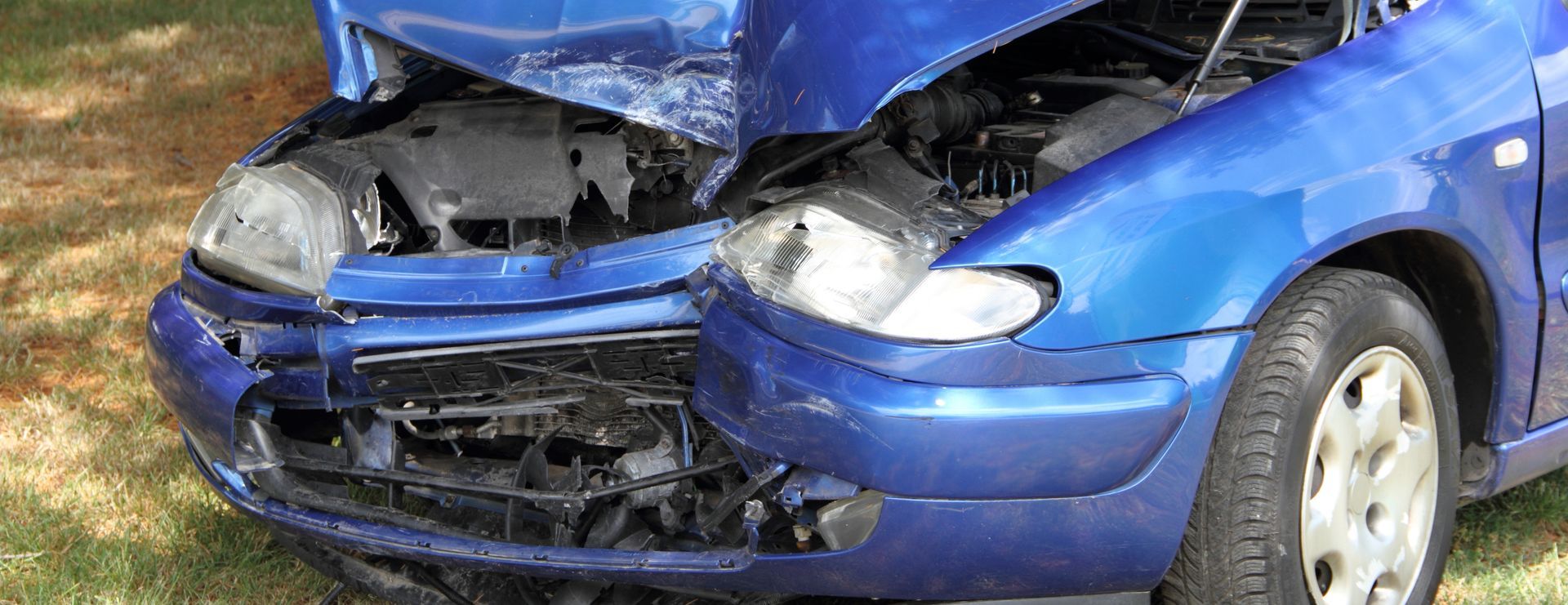 Une épave de voiture bleue accidentée devant