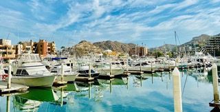 Cabo San Lucas marina boardwalk with luxury yachts and waterfront dining