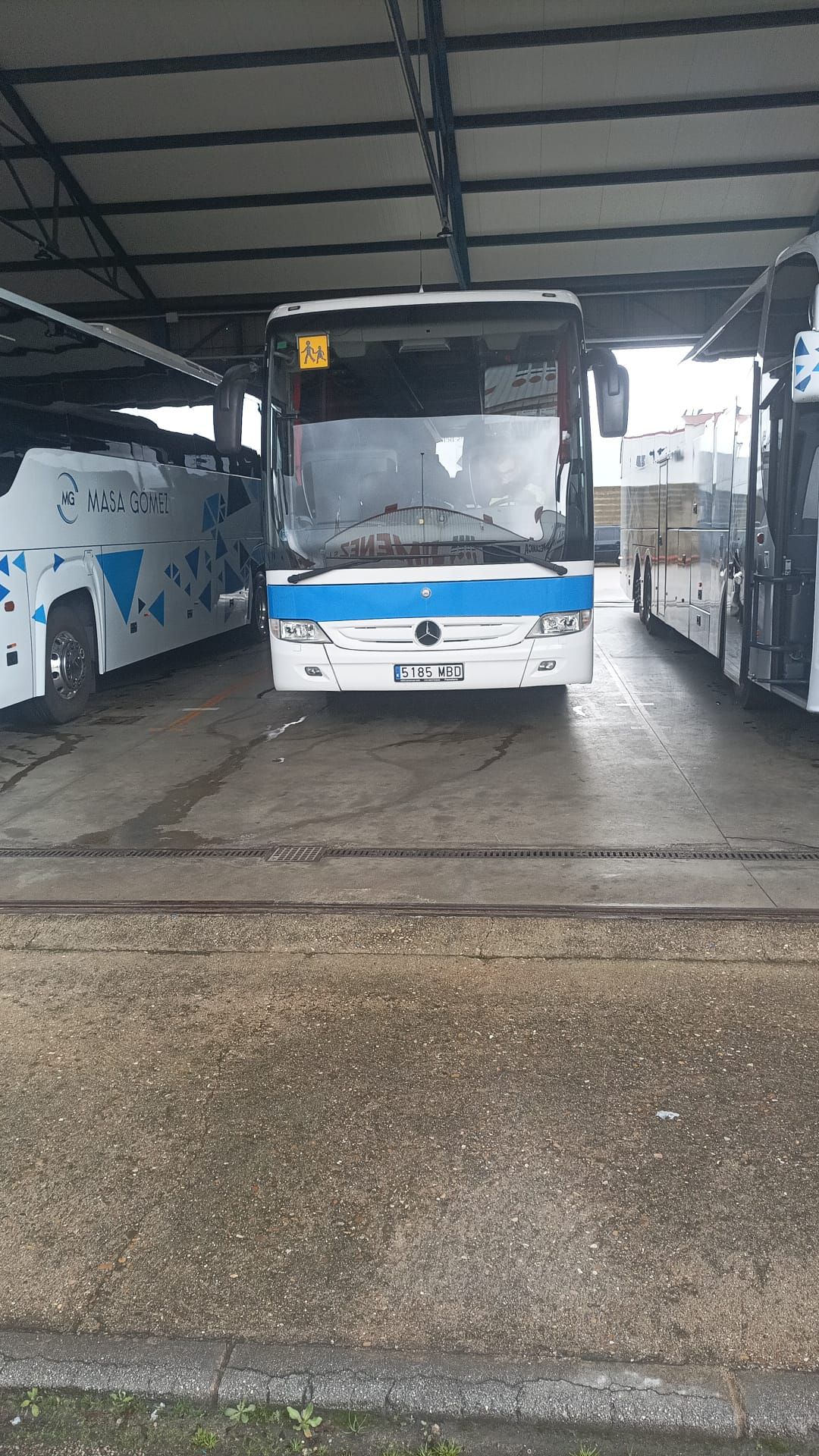 Un autobús azul y blanco está estacionado en un estacionamiento.