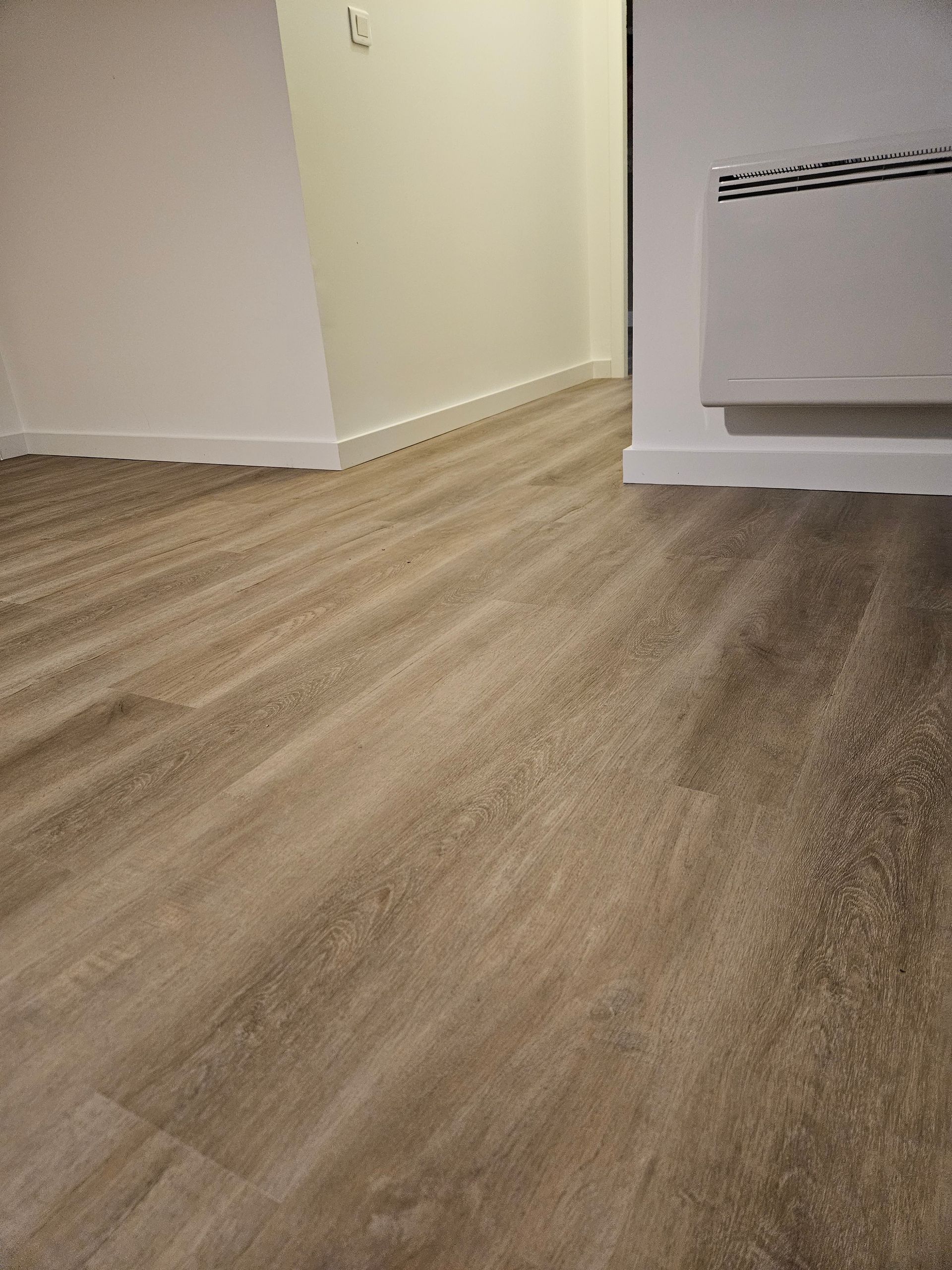 Une personne en train de travailler une lame de parquet