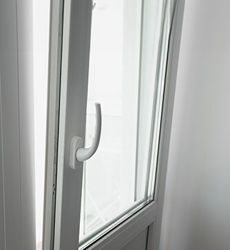 Eine Nahaufnahme eines weißen Kunststofffensters mit einem Griff.
