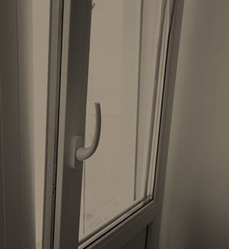 Eine Nahaufnahme eines Fensters mit einem Griff und einer Glastür.