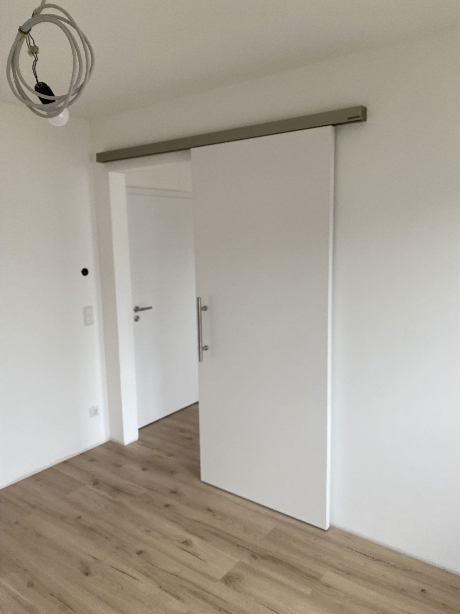 In der Mitte des Raumes befindet sich eine Schiebetür.