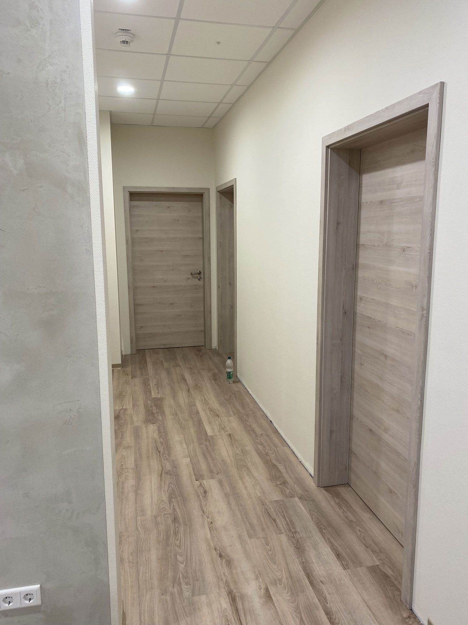 Ein langer Flur mit Holzböden und Holztüren.