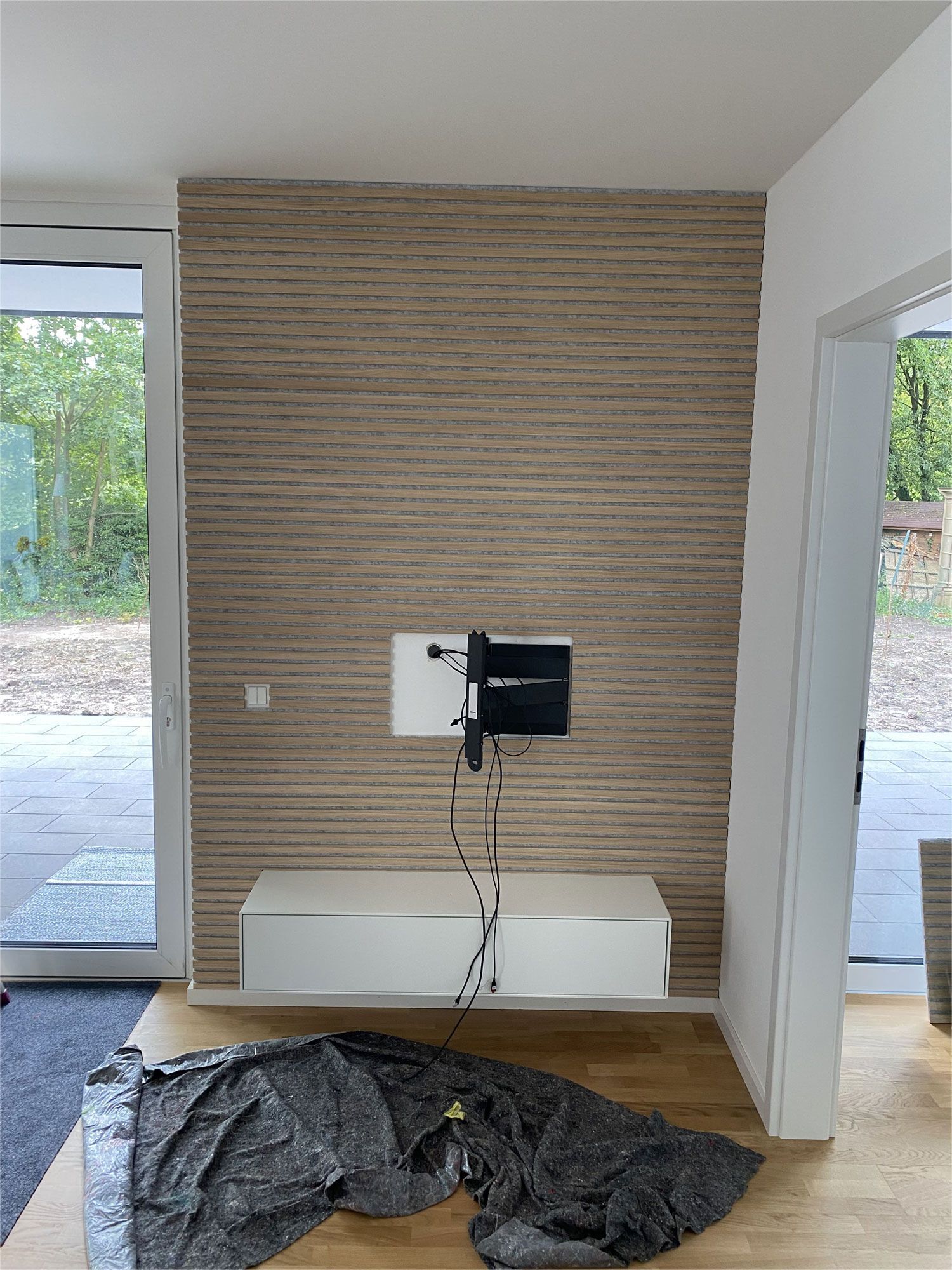 Ein Wohnzimmer mit einem an der Wand montierten Fernseher.