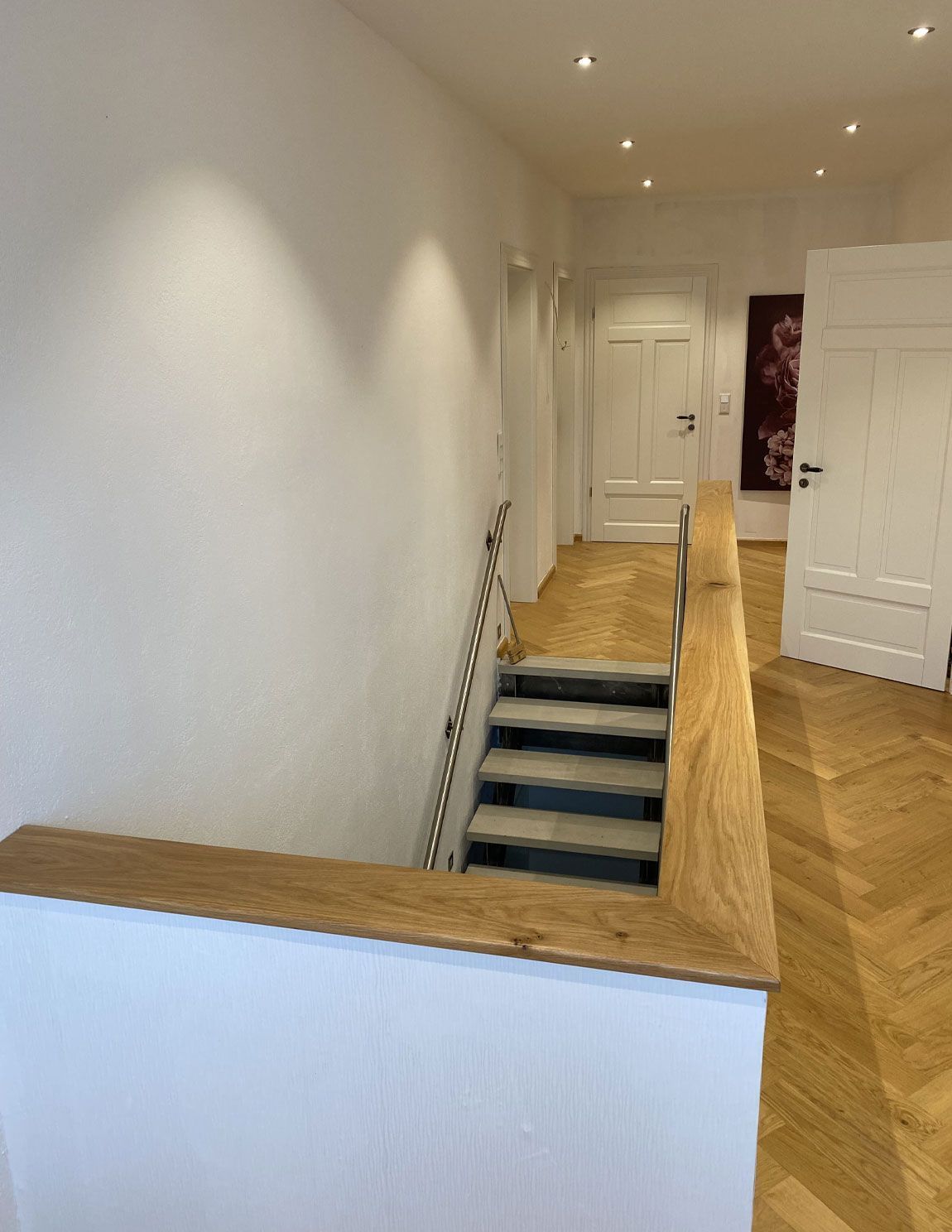 Ein Flur mit Treppe und Holzgeländer