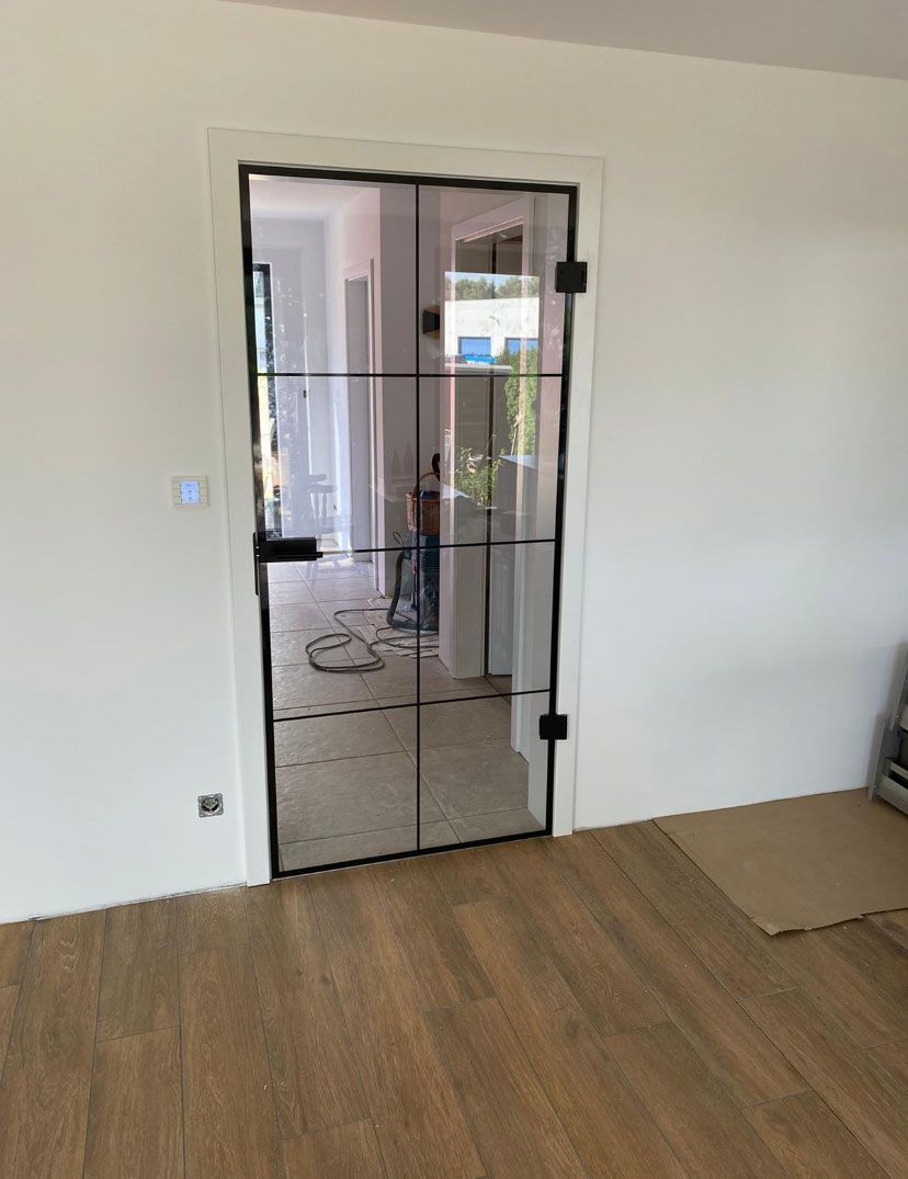 Ein Wohnzimmer mit Glastür und Holzboden.