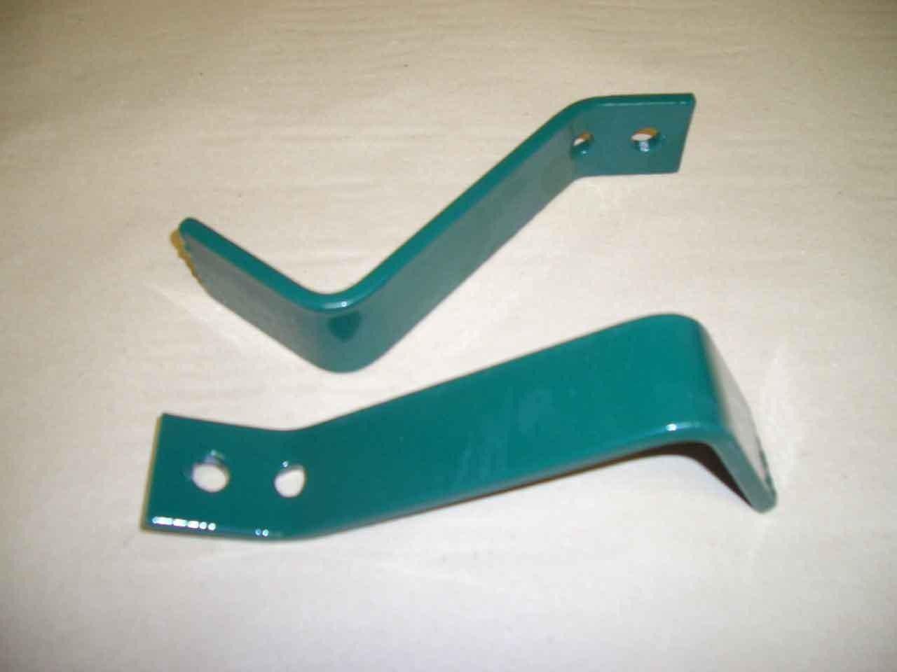 Un par de soportes de metal verdes sobre una superficie blanca.