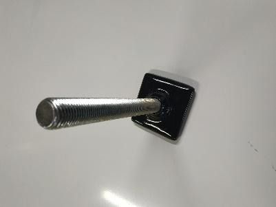 Un primer plano de un perno de metal sobre una superficie blanca.