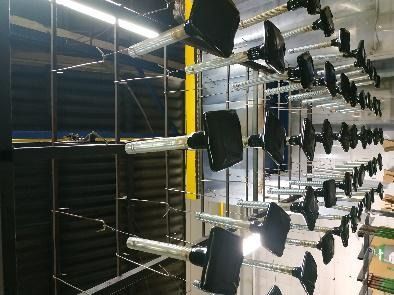 Un montón de mancuernas están colgadas en un estante en una habitación.