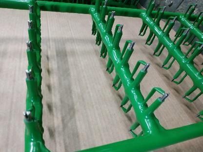 Un montón de tubos verdes con ganchos.