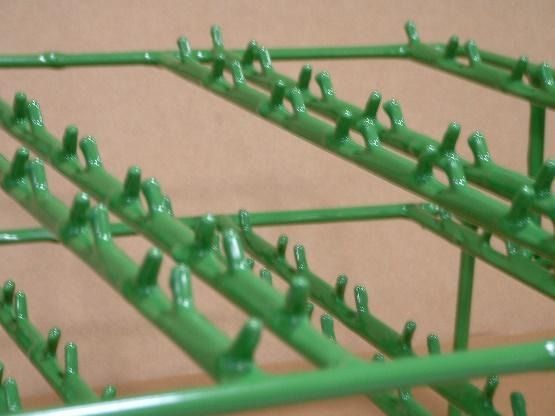 Un primer plano de un estante de metal verde con ganchos.