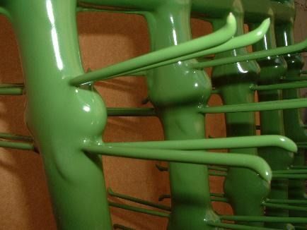 Un primer plano de una estructura de metal verde con ganchos.