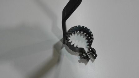 Un primer plano de un objeto metálico sobre una superficie blanca.