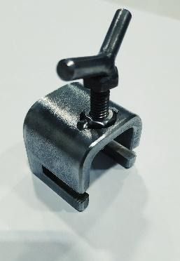 Un primer plano de un objeto de metal con mango sobre una superficie blanca.