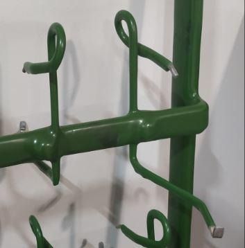 Un poste de metal verde con ganchos unidos a él.