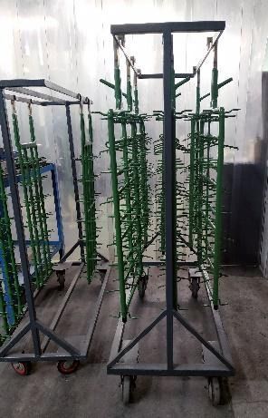 Un montón de carros de metal verde están estacionados en una habitación.