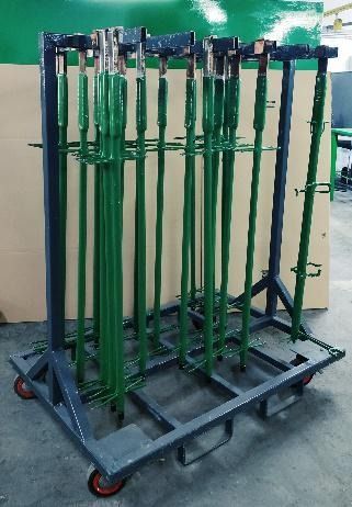 Un carro con un montón de postes verdes sobre él.