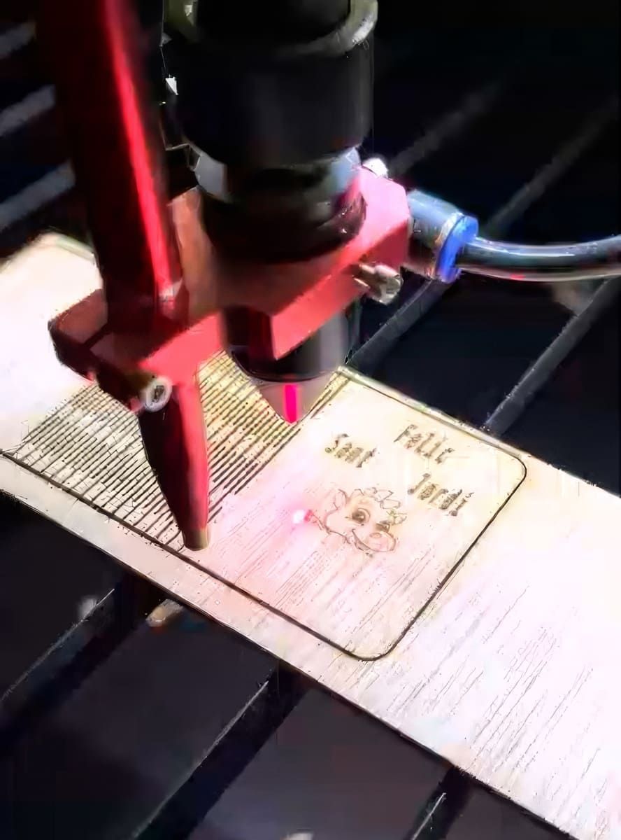 Una máquina está cortando un trozo de madera que dice Sant Jordi.