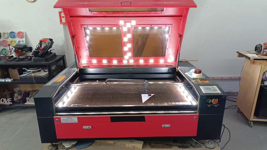 Una máquina está cortando un trozo de madera que dice Sant Jordi.